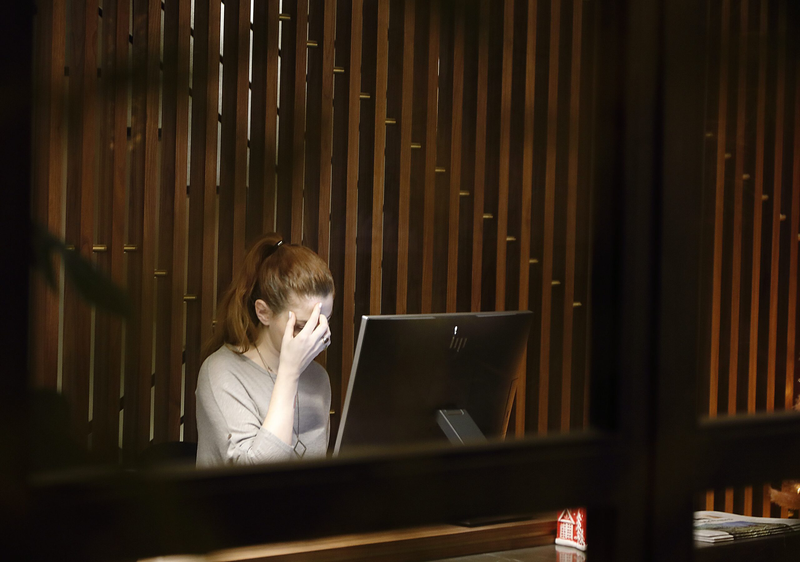 A Woman Sat at Her Computer With Head in Hands